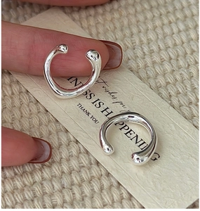 Macro view of S925 sterling silver minimalist ear cuffs with fluid water-drop design