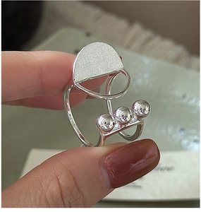Macro detail of S925 silver ring featuring a matte semicircle and three polished beads