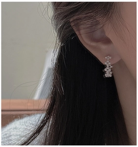 Vue détaillée de boucles d'oreilles créoles en argent 925 portées par un mannequin femme