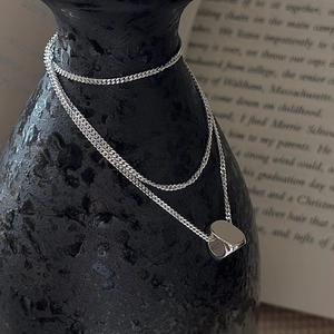 Minimalist S925 silver cylinder pendant necklace on vintage artistic display stand