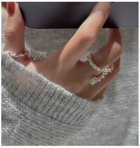 Macro detail of S925 sterling silver layered ring with vintage coin charm on hand