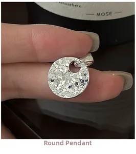 Detail of S925 sterling silver round pendant showing textured surface and S925 hallmark