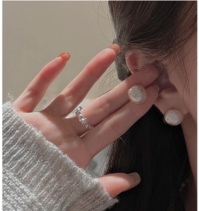 Detail of S925 silver irregular ring and pearl-white star earrings set on model