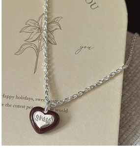 Close-up of S925 silver heart necklace with red enamel and grow engraving detail
