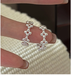Gros plan sur des boucles d'oreilles en argent S925 avec un design de grappes de perles