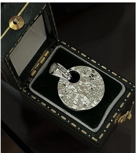 Macro detail of S925 sterling silver hammered pendant in a luxury velvet jewelry box