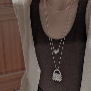 Close-up of S925 silver layered necklace with heart and mesh pendants on model