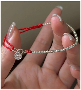 Close-up of S925 silver beads red string bracelet with Peace and Joy engraved pendant
