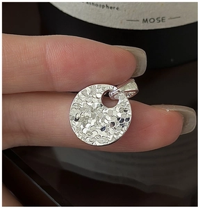 Detailed view of S925 sterling silver round pendant with hand-hammered textured finish