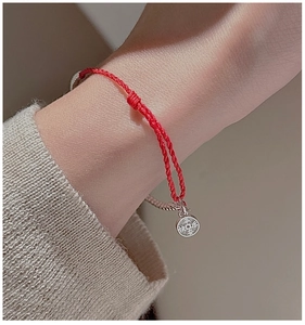 Macro shot of S925 silver red string bracelet with Ping An Xi Le lucky charm pendant