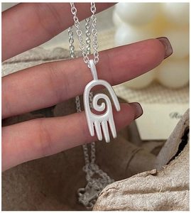 Vue macro du pendentif main mat en argent S925 avec détails de texture spirale