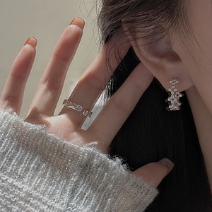 Boucles d'oreilles perlées en argent S925 et bague texturée portées par un mannequin