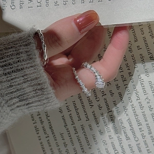 S925 sterling silver ring set with spiral texture and square stone on a book background