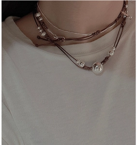 Détail du collier multicouche en argent S925 avec corde tressée et pendentif en perle