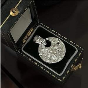 Detailed close-up of S925 sterling silver hallmark on a hammered texture round pendant