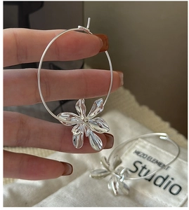 Detailed close-up of S925 sterling silver hoop earrings with textured floral pendant