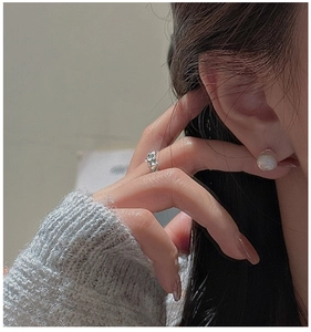 Close-up of elegant S925 sterling silver star stud earrings with a minimalist round pearl
