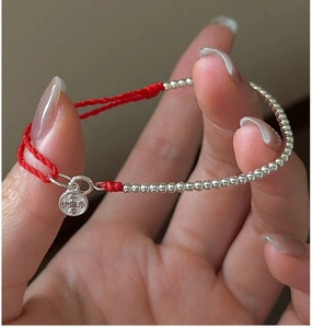 Close-up of S925 sterling silver red string bracelet with Peace and Joy engraved pendant
