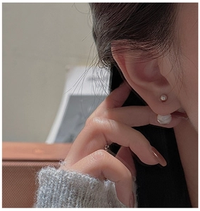 Detail of S925 silver stud earring featuring a polished metal bead and elegant white pearl