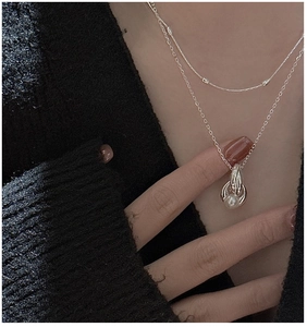 Detailed close-up of double-layer S925 silver necklace with twisted rings and pearl