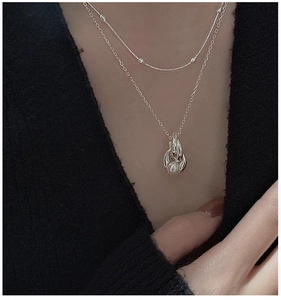 Detail view of S925 sterling silver double-layered necklace with pearl and interlocking rings