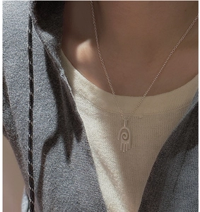 Gros plan d'un collier en argent S925 avec pendentif géométrique mat sur le cou
