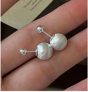Detail of S925 sterling silver star-engraved stud earrings with brushed metallic finish