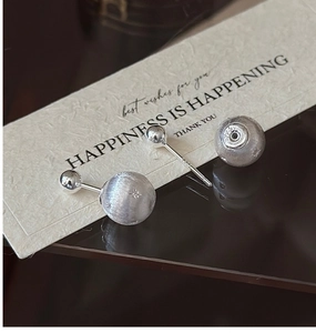 Close-up of S925 sterling silver brushed star earrings with matte ball texture