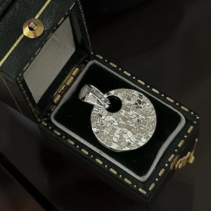Polished S925 sterling silver round pendant with textured hammer finish in a jewelry box
