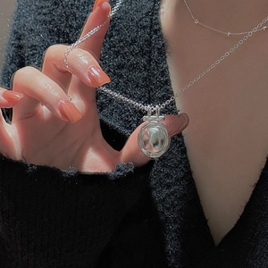 Minimalist S925 sterling silver necklace with textured oval hammered pendant on black sweater