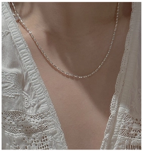 Close-up of minimalist S925 sterling silver olive bead chain necklace on a model