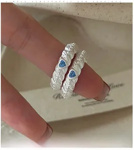 Macro shot of silver textured ring featuring a heart-shaped blue zircon stone