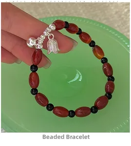 Detailed shot of S925 silver beaded bracelet with red agate and tulip pendant