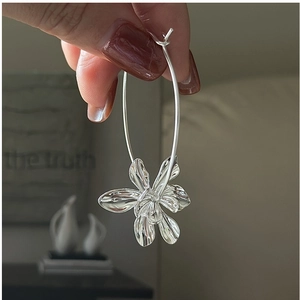 Detail of silver S925 flower pendant hoop earring with intricate 3D petal texture