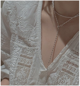 Close-up of S925 sterling silver olive bead double-layered necklace on white lace blouse