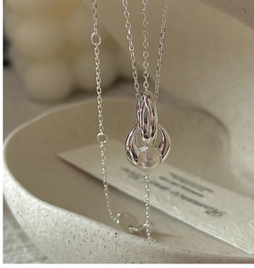 Detail of silver S925 necklace featuring interlocking oval rings and a lustrous white pearl