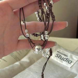 Collier minimaliste en argent S925 avec perles polies et cordon tressé tenu à la main