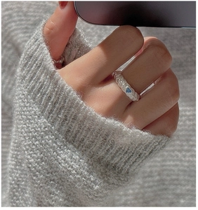 Close-up of S925 silver heart ring with blue zircon and textured band on hand