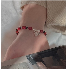 Detailed shot of retro silver tulip charm and red agate beads on a vintage bracelet