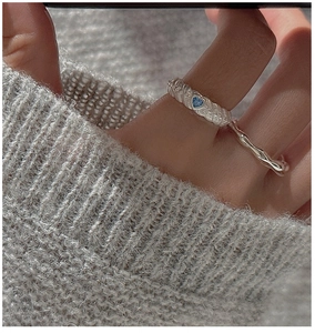 Close-up of S925 sterling silver rope ring with heart-shaped blue zircon on hand
