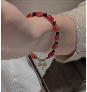 Detail of vintage silver bracelet with red agate beads and tulip bell charms