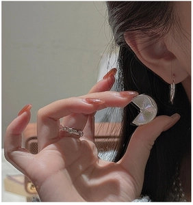 Detail of S925 silver iridescent shell earrings and irregular wavy textured ring set