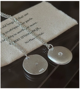 Macro detail of S925 sterling silver necklace showing matte finish and hallmark engraving