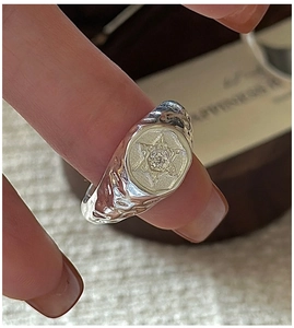 Macro shot of S925 sterling silver hexagon ring with textured finish and star motif