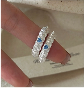 Detail of S925 silver lava texture rings featuring blue heart zircon on fingers