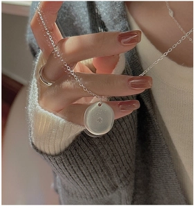 Close-up of S925 silver irregular round pendant necklace with zircon on a person