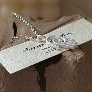 Collier pendentif main de Fatima en argent massif S925 mat sur fond papier bio