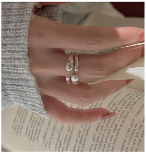 Macro shot of silver S925 cross texture open ring styled on hand with book background