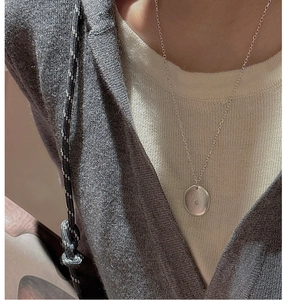 Close-up of minimalist S925 sterling silver coin pendant necklace worn on a model