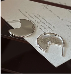Detailed macro view of S925 silver geometric earrings with polished finish and tiny zircon